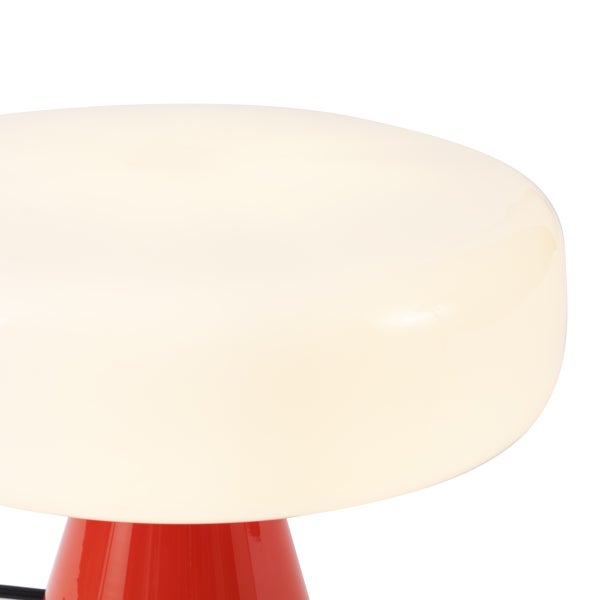 Nahaufnahme einer pilzförmigen Tischleuchte mit einem großen weißen Glasschirm und einem roten Fuß.