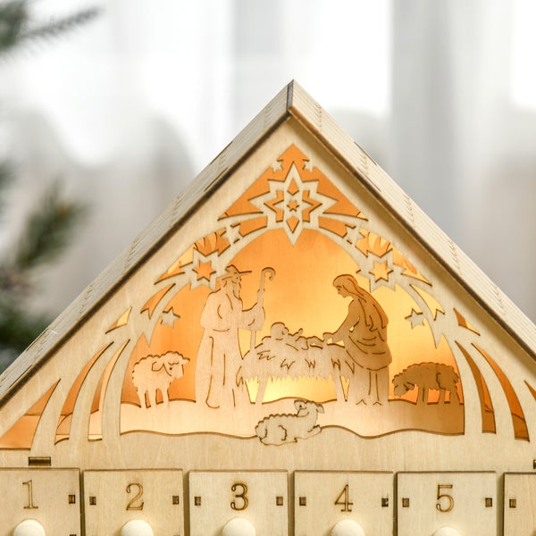 Adventskalender aus Holz mit beleuchteter Weihnachtskrippe und nummerierten Schubladen.