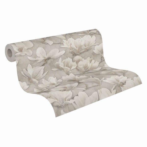 Eine Tapetenrolle mit Blumenmuster zeigt großflächige Magnolienblüten in einem eleganten Design auf strukturiertem Untergrund.