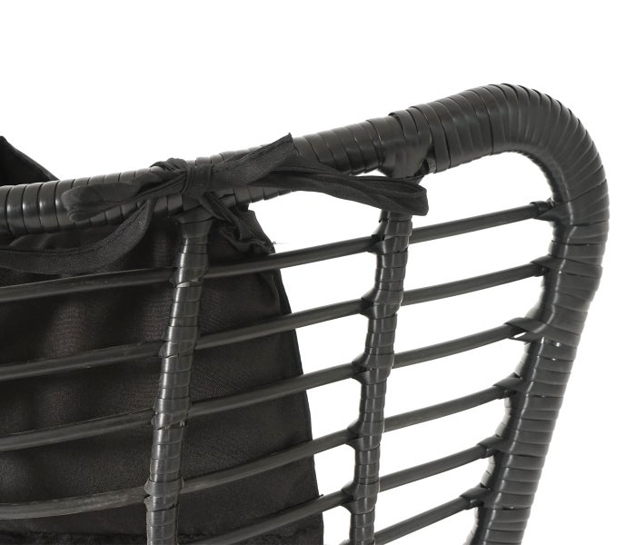 Detailansicht eines schwarzen Rattansessels mit Stoffbezug