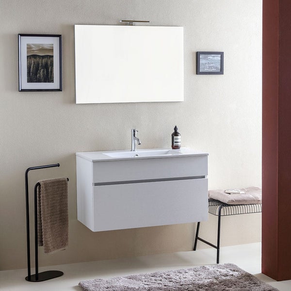 Modernes Badezimmer mit hängendem Waschtisch, Spiegel mit Beleuchtung, Handtuchhalter und Sitzbank vor einer schlichten Wand.