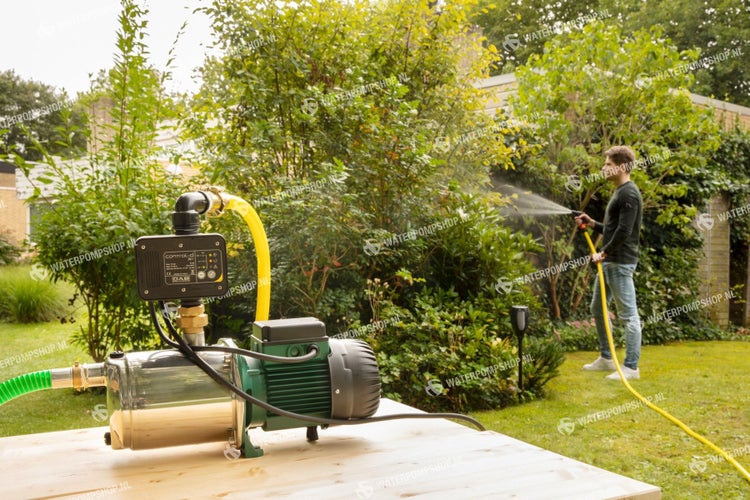 Hauswasserwerk mit Drucksteuerung im Außeneinsatz mit Person, die den Garten bewässert