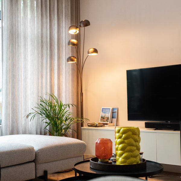 Wohnzimmer mit Stehlampe, Fernseher und Dekorationen
