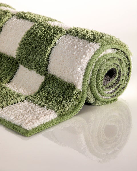 Eingerollte Badematte mit Karomuster in Grün und Weiß, weicher Hochflor.