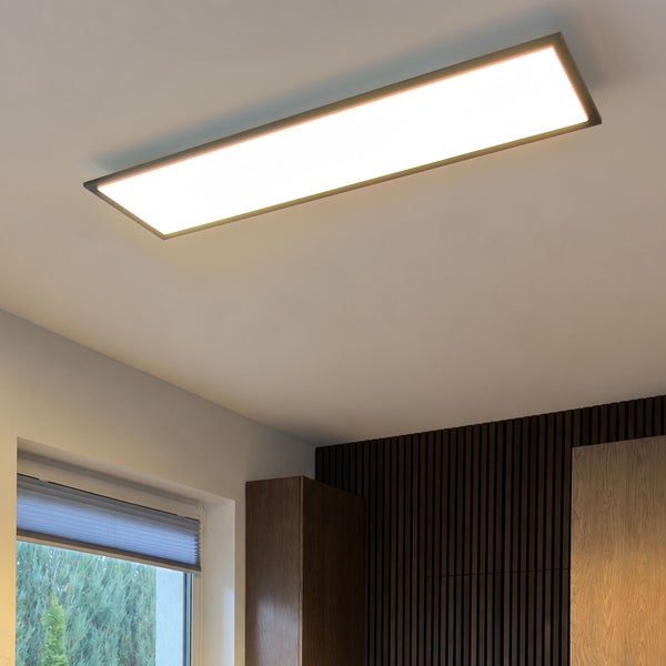 Rechteckige LED Deckenleuchte mit flachem Design, montiert an einer hellen Zimmerdecke in einem modern eingerichteten Raum.
