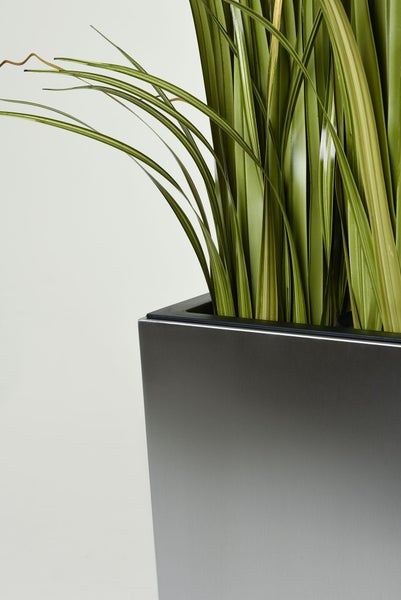 Quadratischer Pflanzkübel in Silber-Optik mit künstlichem Ziergras.