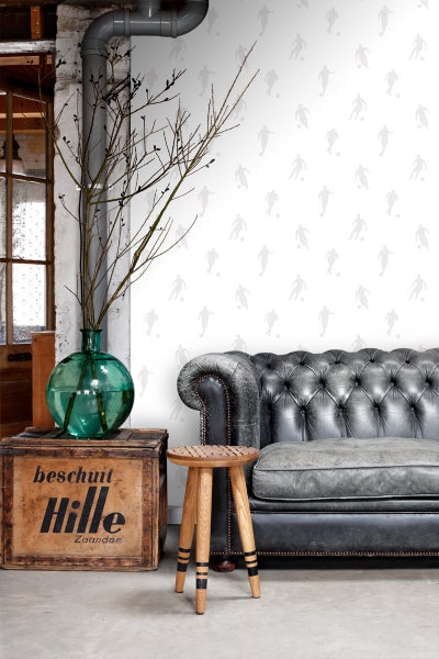 Dekoratives Interieur mit Sofa, Hocker und einer Holzkiste mit Aufschrift
