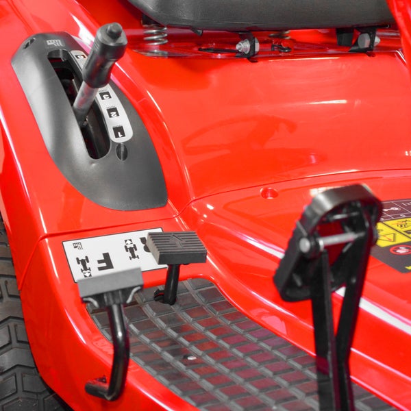 Detailansicht eines Rasentraktors mit Bedienelementen und Fußpedalen.