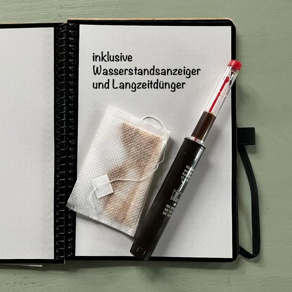 Abbildung eines Wasserstandsanzeigers und Langzeitdüngers neben einem Notizblock
