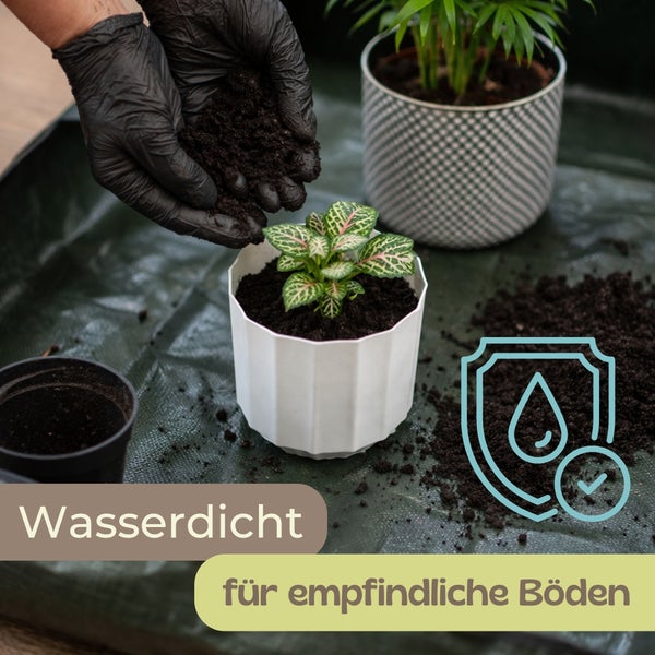 Person mit Handschuhen beim Umtopfen einer Pflanze auf einer wasserdichten Gartenmatte zum Schutz empfindlicher Böden. Symbol wasserdicht.