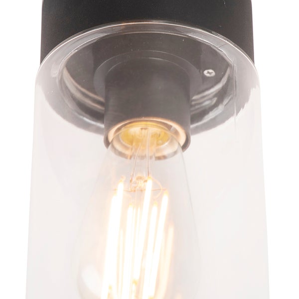 Detailansicht einer Leuchte mit klarem Glaszylinder, leuchtendem LED-Filament-Leuchtmittel und schwarzem Sockel.