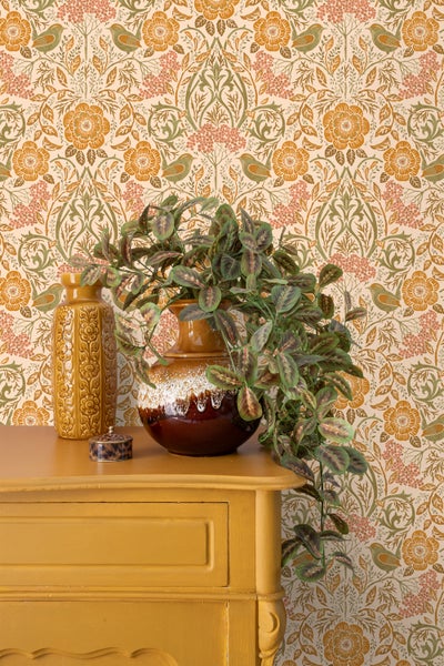 Dekoratives Interieur mit floral gemusterter Tapete, Kommode, Vasen und Topfpflanze