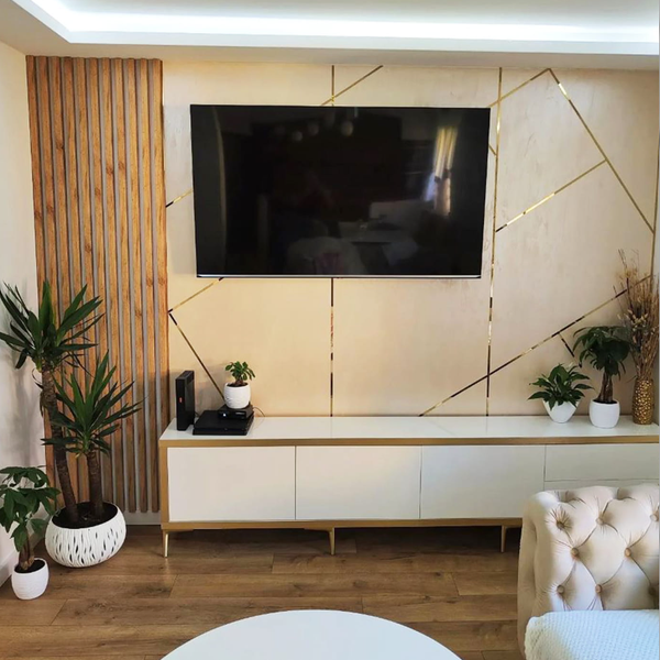 Wohnzimmer mit Holzpaneelwand, Fernsehgerät und weißen Möbeln