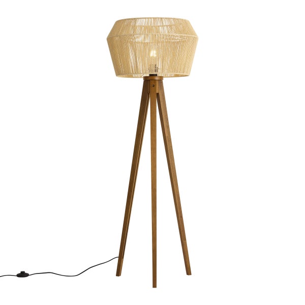 Dreibein-Stehleuchte aus Holz mit einem geflochtenen Lampenschirm und Fußschalter am Kabel.