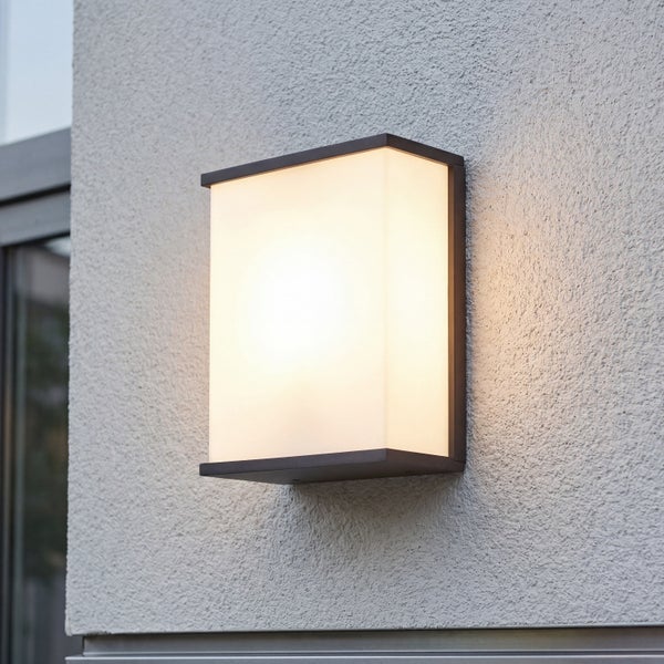 Moderne, rechteckige Außenwandleuchte mit warmem Licht an einer verputzten Hauswand.