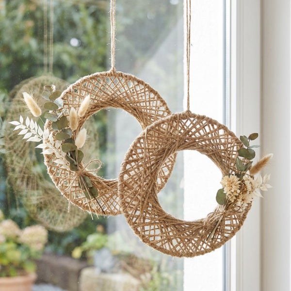Zwei dekorative Hängeringe aus Juteseil mit Trockenblumen und Eukalyptus als Fensterdekoration.