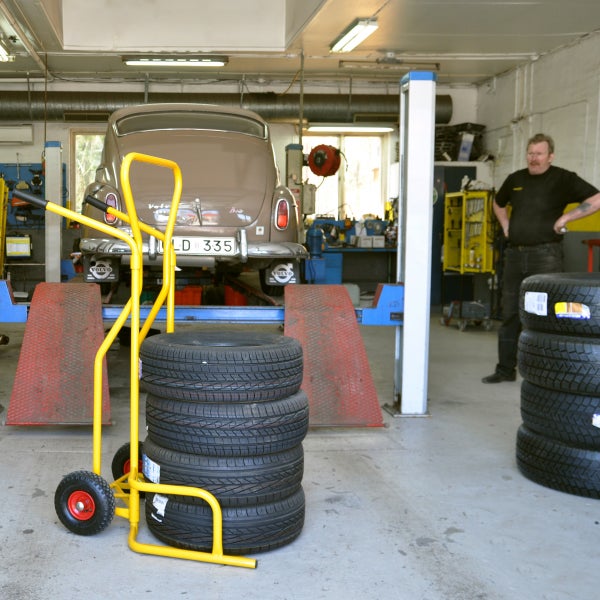 Werkstatt mit Reifenwagen, Reifenstapel und Hebebühne mit Auto