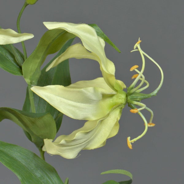 Künstliche Gloriosa Blume mit hellgelben Blüten und grünen Blättern.