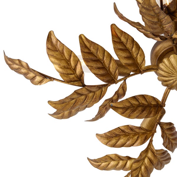 Detailansicht einer Leuchte mit dekorativen Blättern aus Metall in Gold-Optik.