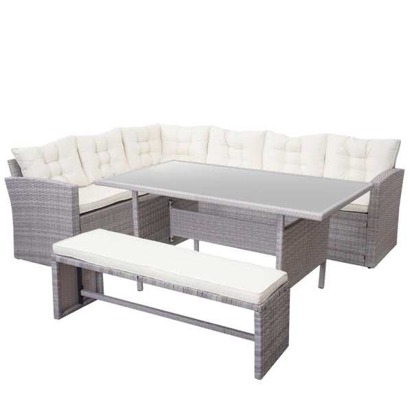 Graues Gartenmöbel-Set aus Polyrattan bestehend aus Ecksofa, Tisch mit Glasplatte und Sitzbank inklusive cremefarbener Auflagen.