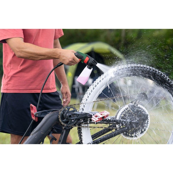 Person reinigt ein Fahrrad mit einer Reinigungslanze.