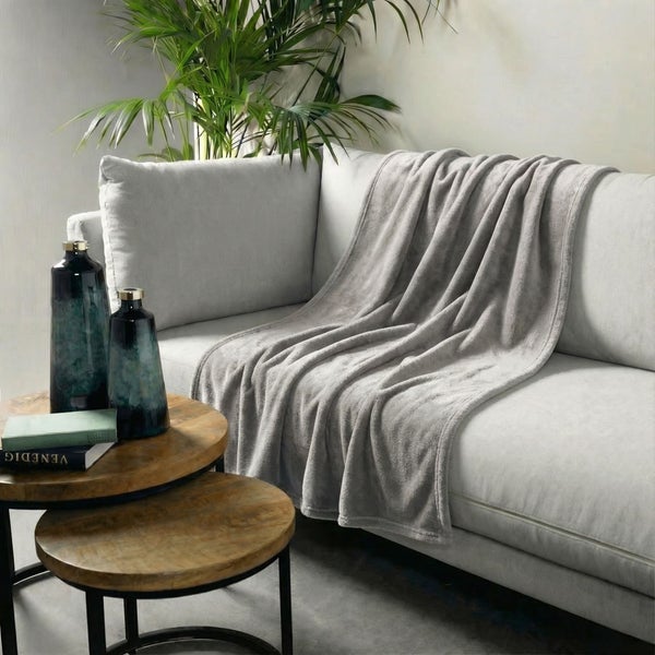 Wohnzimmerszene mit Sofa, Tagesdecke und Beistelltisch