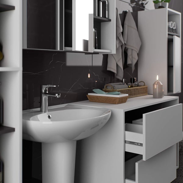 Badezimmerwaschbecken mit Unterschrank, Spiegelschrank und Handtüchern vor schwarzer Marmorwand