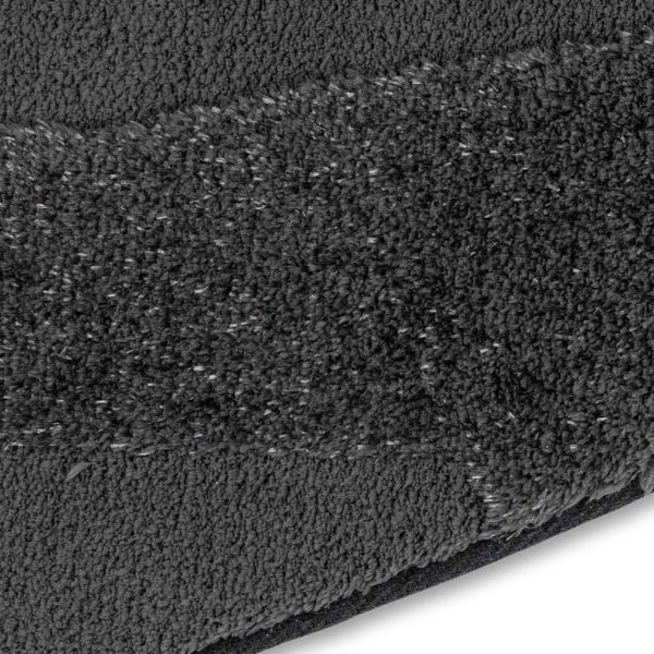 Nahaufnahme einer anthrazitfarbenen Badematte aus weichem Textil mit gestreifter Struktur und unterschiedlichen Florhöhen.