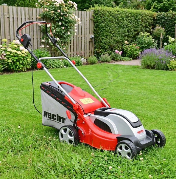 Roter und grauer Rasenmäher der Marke Hecht im Garten