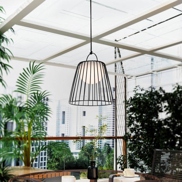 Moderne Außenpendelleuchte mit schwarzem Drahtkäfig und weißem Kugeldiffusor in einem hellen, großzügigen Wintergarten mit Pflanzen.