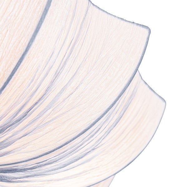 Detailaufnahme eines strukturierten Lampenschirms mit wellenförmiger Oberfläche.