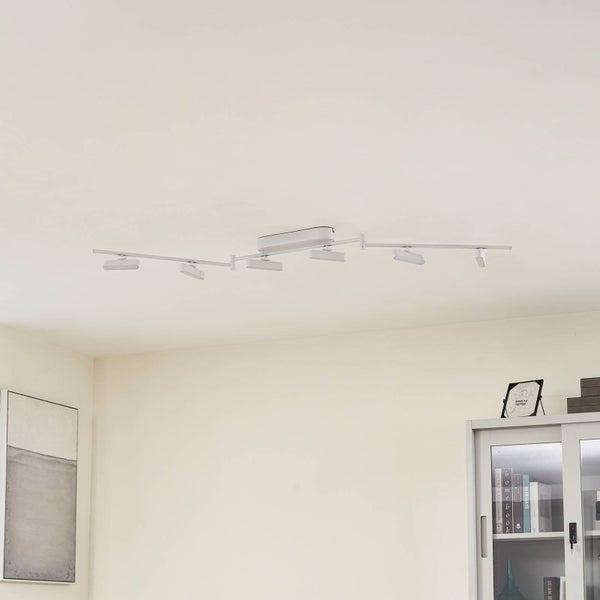 Moderner sechsflammiger Deckenstrahler in Weiß mit verstellbaren Armen und flachen LED-Spots in einem hellen, aufgeräumten Wohnraum.