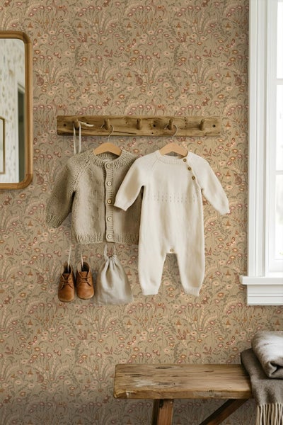 Vliestapete mit Naturmuster aus Blumen und Waldtieren in einem Kinderzimmer mit Holzgarderobe und Babykleidung.