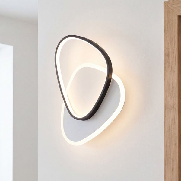 Moderne LED Wandleuchte in abstraktem Design aus zwei überlappenden organischen Formen mit warmweißem Licht.