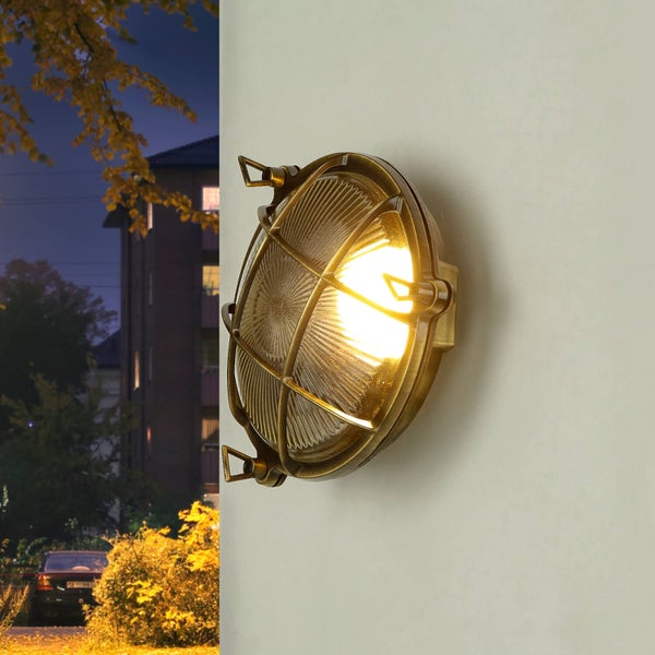 Runde Außenwandleuchte mit Schutzgitter an einer Wand montiert