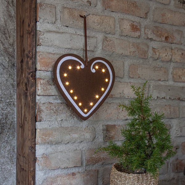 Dekorative, weiße Lichterbögen mit Weihnachtsmotiven und LED-Kerzen auf Tisch