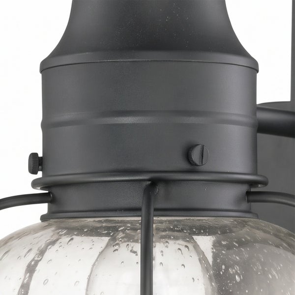 Detailansicht einer Außenwandleuchte mit Metallgehäuse und Strukturglaskuppel.