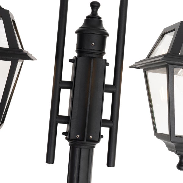 Detailansicht einer schwarzen Außenstehleuchte aus Metall mit mehreren Laternenköpfen und Klarglas.