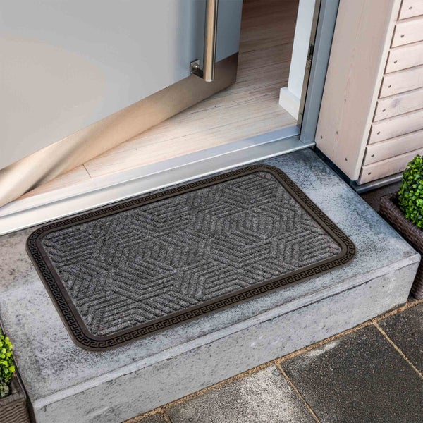 Fußmatte mit geometrischem Muster vor einer geöffneten Haustür