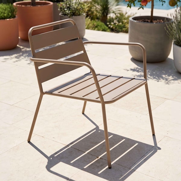 Moderner Gartenstuhl aus Metall mit Armlehnen und Sitzfläche aus Latten auf einer hellen Steinterrasse mit Pflanzgefäßen im Hintergrund.