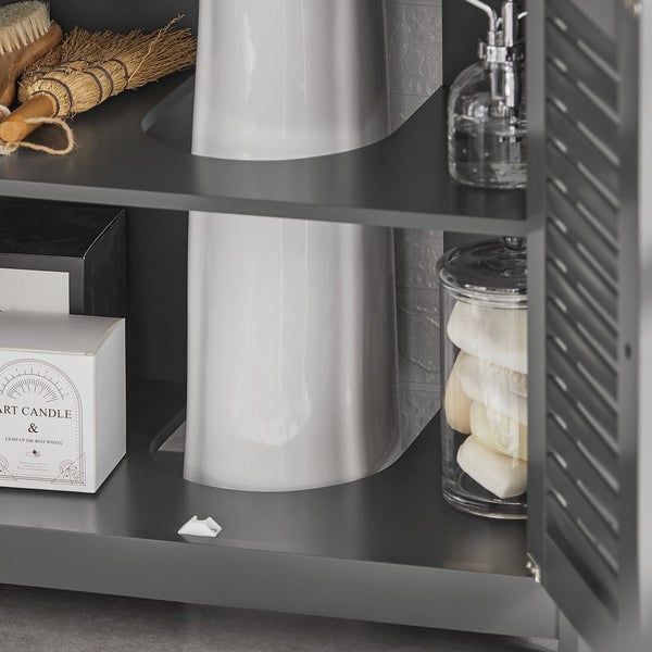 Detailansicht eines Badezimmerschranks mit Waschbecken, Bürsten, Kerze, Seife und Spender