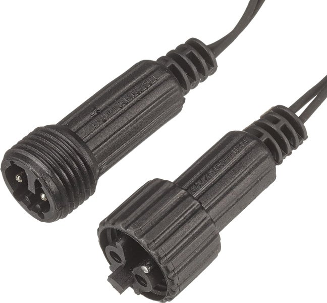 Szene mit zwei grauen Rattanhängelampen über einem Esstisch im Freien.