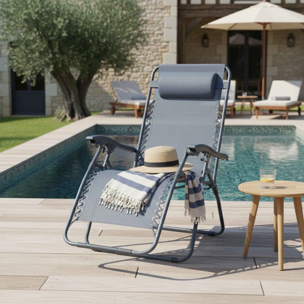 Verstellbarer Garten-Relaxsessel am Pool mit Kopfstütze, gestreiftem Handtuch und Strohhut auf einer hellen Holzterrasse.