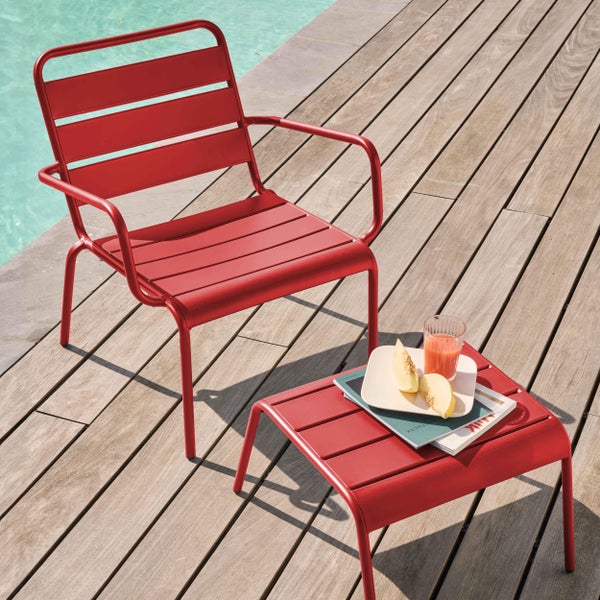 Roter Garten-Lounge-Sessel und Beistelltisch aus Metall auf einer Holzterrasse am Pool.