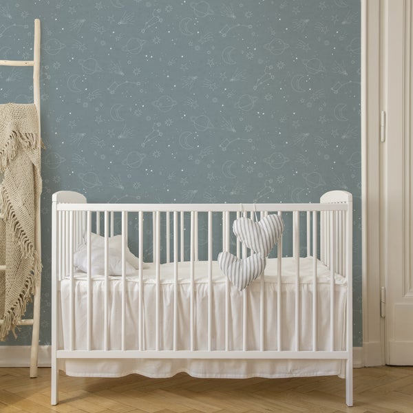 Kinderzimmer mit Gitterbett und Tapete mit Sternen- und Planetenmuster