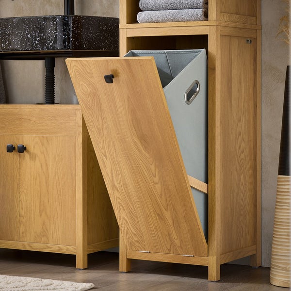 Badezimmer Szene mit einem Holzschrank mit Wäschekippe und einem grauen Wäschekorb