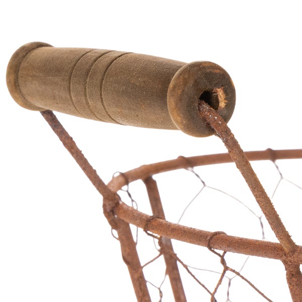 Detailansicht eines rostigen Metalldrahtkorbs mit Holzgriff.