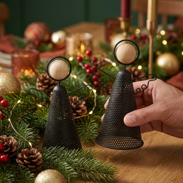 Zwei dekorative Weihnachtsengel aus Lochblech mit Holzkopf auf einem weihnachtlich dekorierten Holztisch