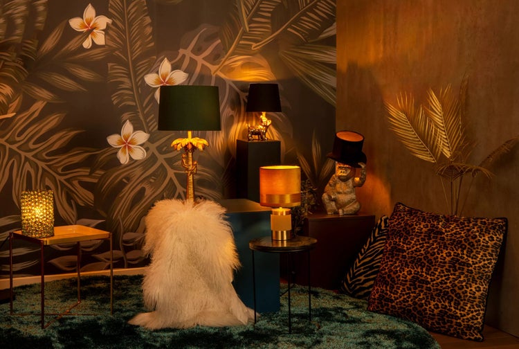 Dekoratives Interieur mit Lampen, Kissen und Beistelltischen auf einem Teppich