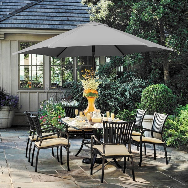 Gartenmöbel-Set mit Tisch, Stühlen und Sonnenschirm auf einer Terrasse.